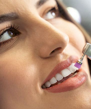 Woman receiving dental injection, smiling with healthy teeth visible during treatment.