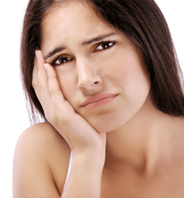 Woman with concerned expression touching her face, depicting dental discomfort or tooth pain.