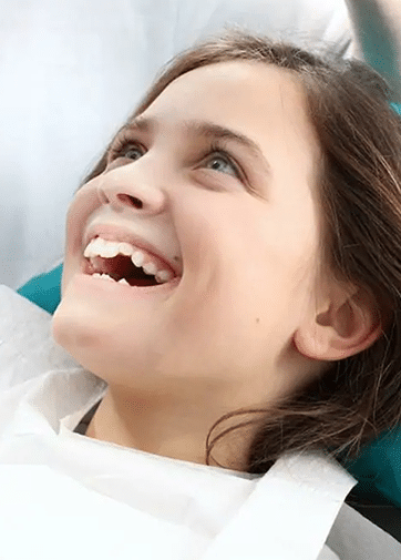 Young patient smiling brightly during dental examination at Danville Family Dental office.