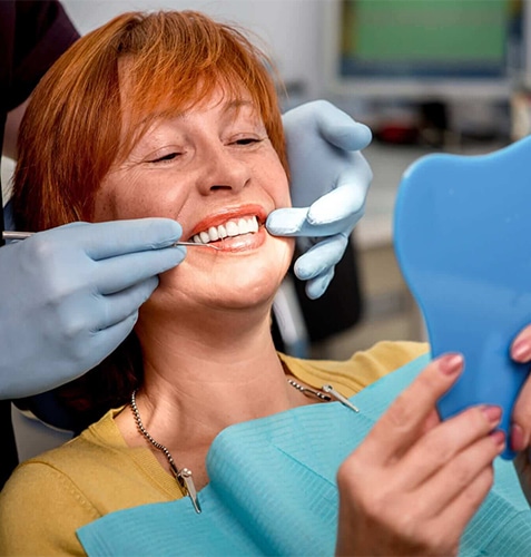 Woman receiving dental examination from dentist wearing gloves in modern dental office.