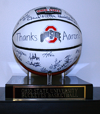 Signed Ohio State basketball commemorating Aaron, displayed on black base with plaque.