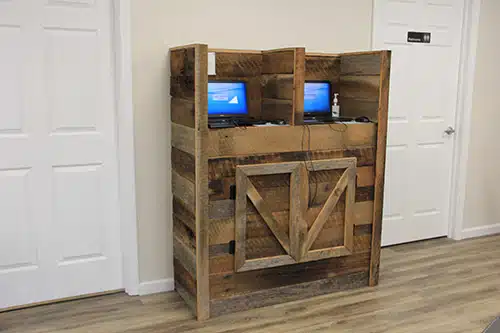 Rustic wooden cabinet with X-design doors and blue monitors displayed in dental office hallway.